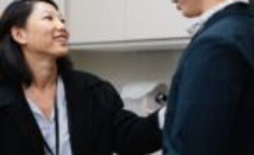 Two Asian adults having a supportive conversation in a quiet workplace